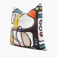Side view of abstract art throw pillow cushion in white, red, blue, and yellow