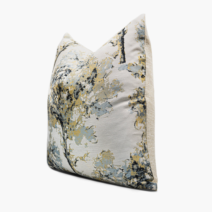 Side view of a golden throw pillow cushion featuring a watercolor tree motif
